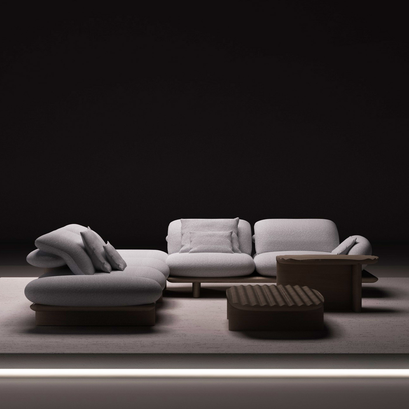 Canapé d’angle design gris clair aux formes organiques, accompagné de tables basses en bois sur une plateforme éclairée, dans une ambiance minimaliste et contemporaine.