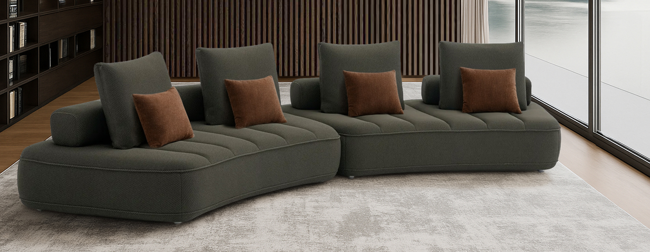 Contemporary modular sofa in anthracite, featuring three curved sections with quilted seats and several matching rectangular cushions.
