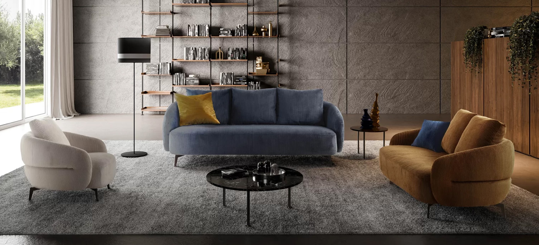 Salon moderne avec un canapé bleu en velours côtelé, une banquette jaune moutarde et un fauteuil crème, disposés sur un tapis gris avec une décoration minimaliste et une bibliothèque murale.
