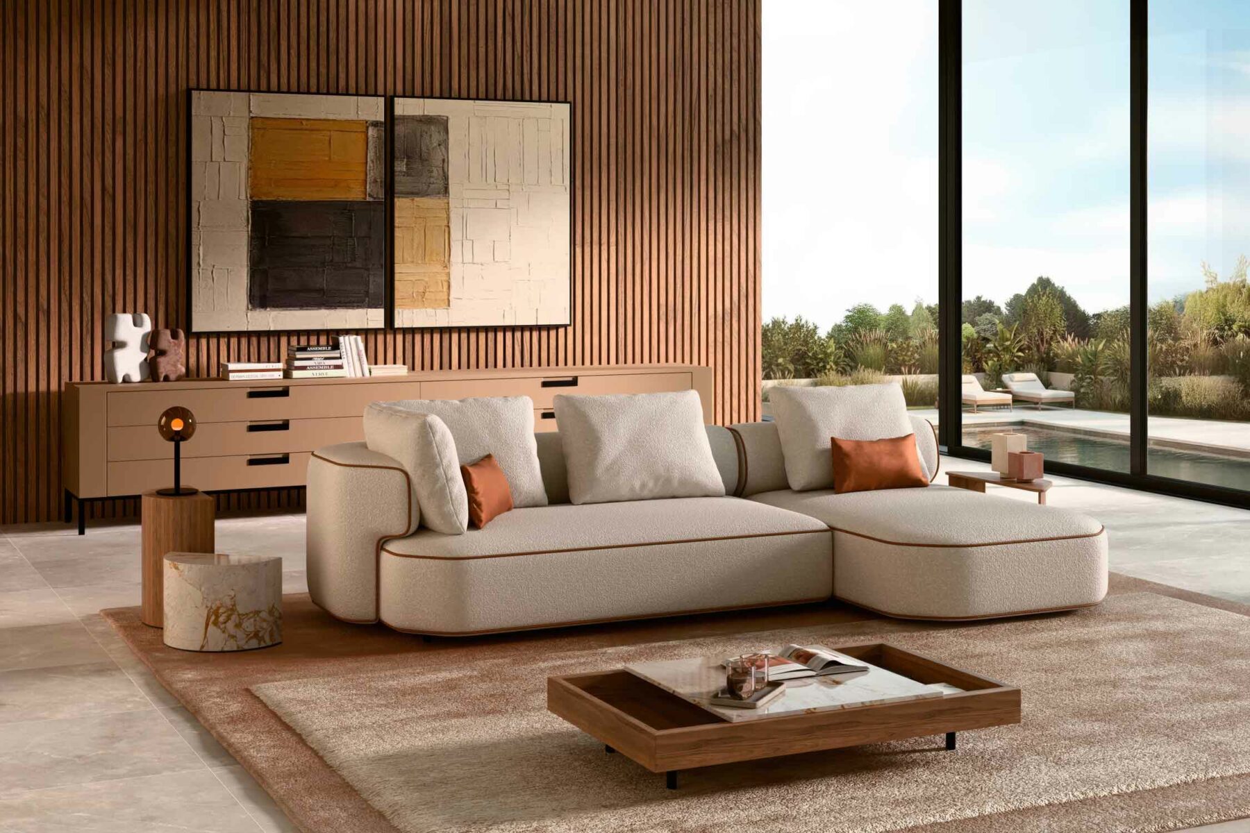 Canapé d’angle contemporain aux lignes arrondies, habillé d’un tissu texturé écru avec finitions en cuir chaud, installé dans un salon moderne aux murs en lames de bois, œuvres abstraites et larges baies vitrées ouvertes sur une terrasse paysagée.