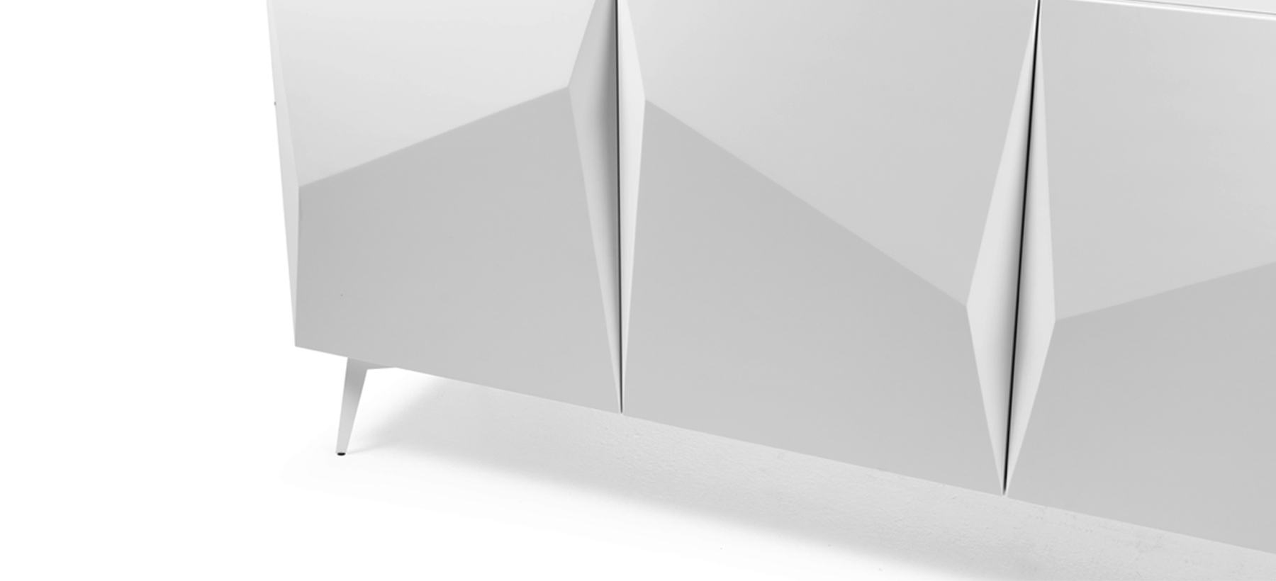 White lacquered four-door sideboard, featuring sculpted facades with geometric pleated detailing and resting on slender metal legs.