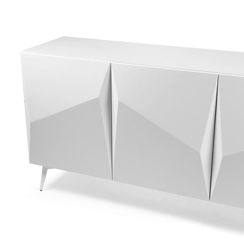White lacquered four-door sideboard, featuring sculpted facades with geometric pleated detailing and resting on slender metal legs.