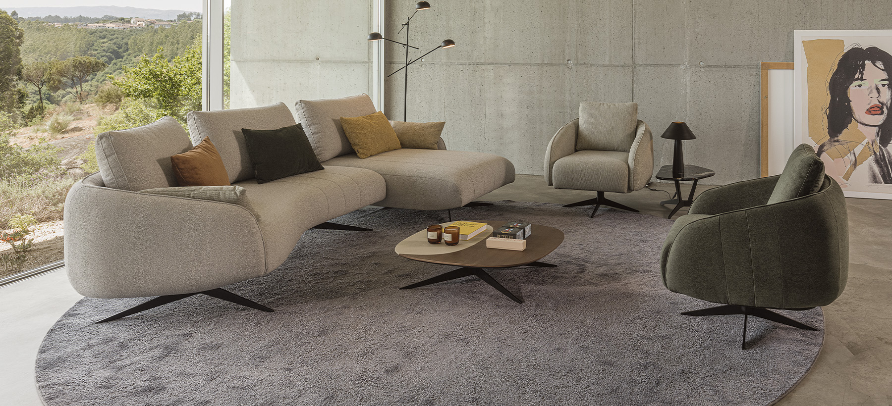 Sculptural sofa with an elongated silhouette, textured beige upholstery, recessed slim legs, and organic lines inspired by pebbles.