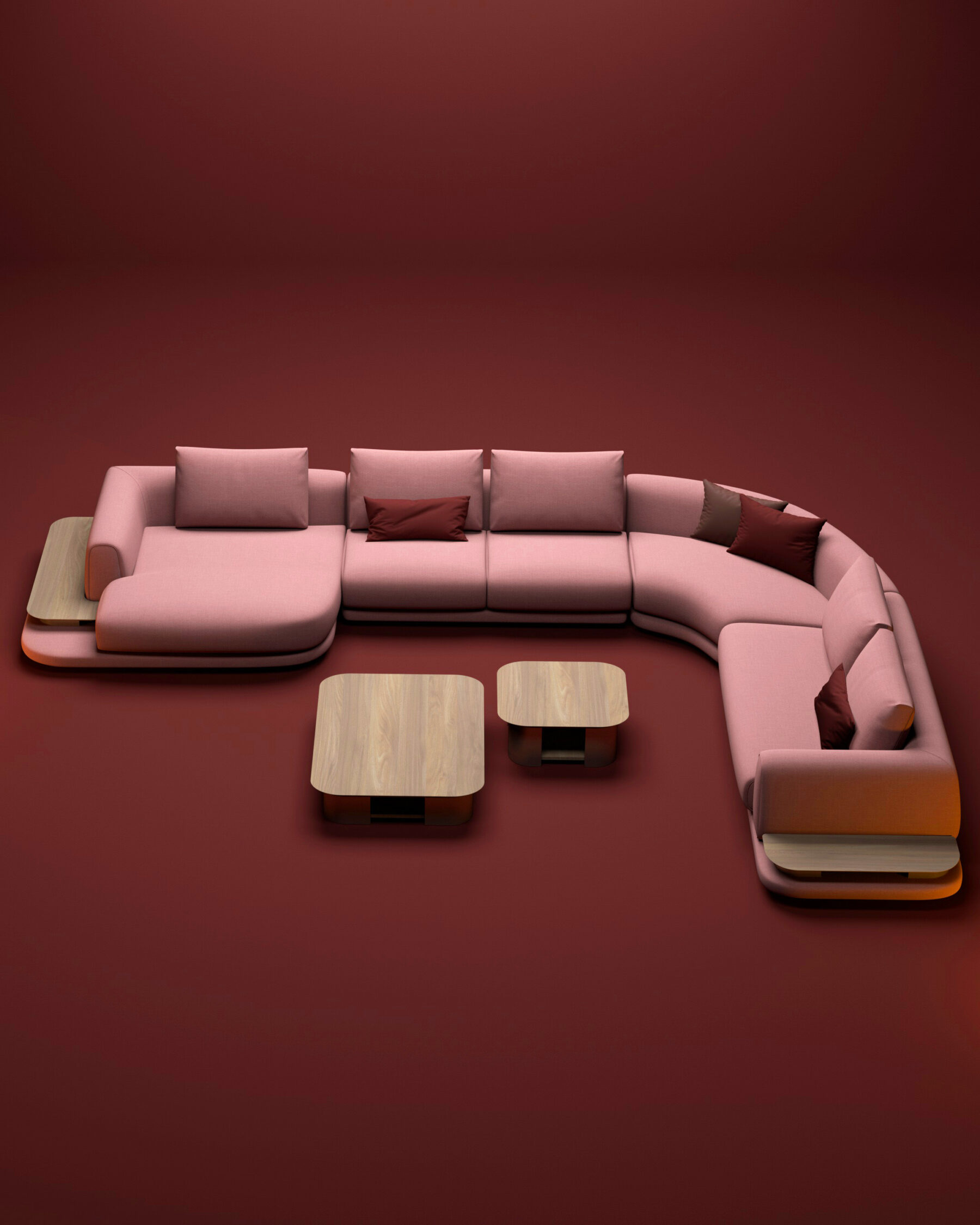 Canapé d’angle modulable rose et rouge avec tables intégrées en bois clair, présenté dans un espace minimaliste aux tons chauds.