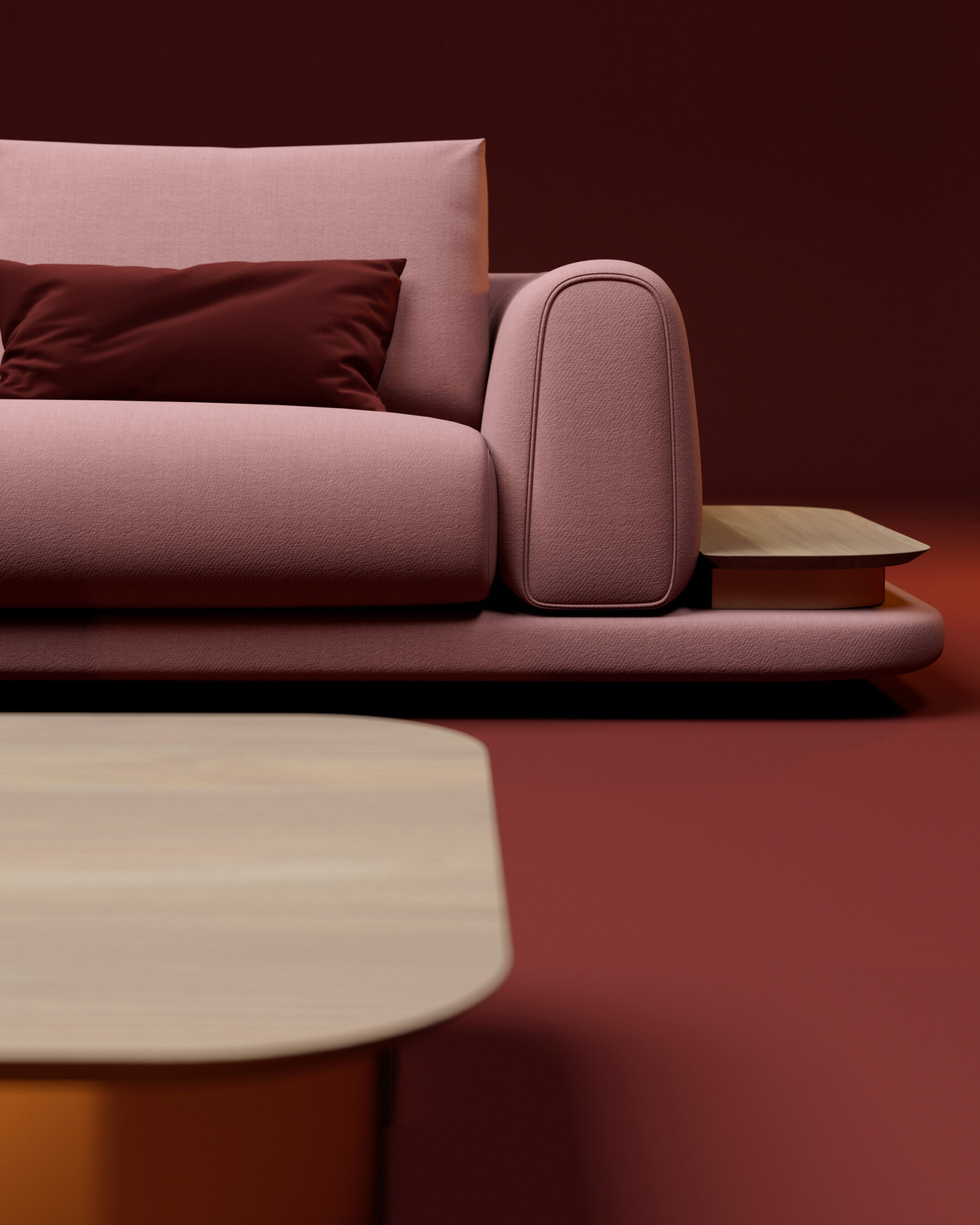 Canapé d’angle modulable rose et rouge avec tables intégrées en bois clair, présenté dans un espace minimaliste aux tons chauds.