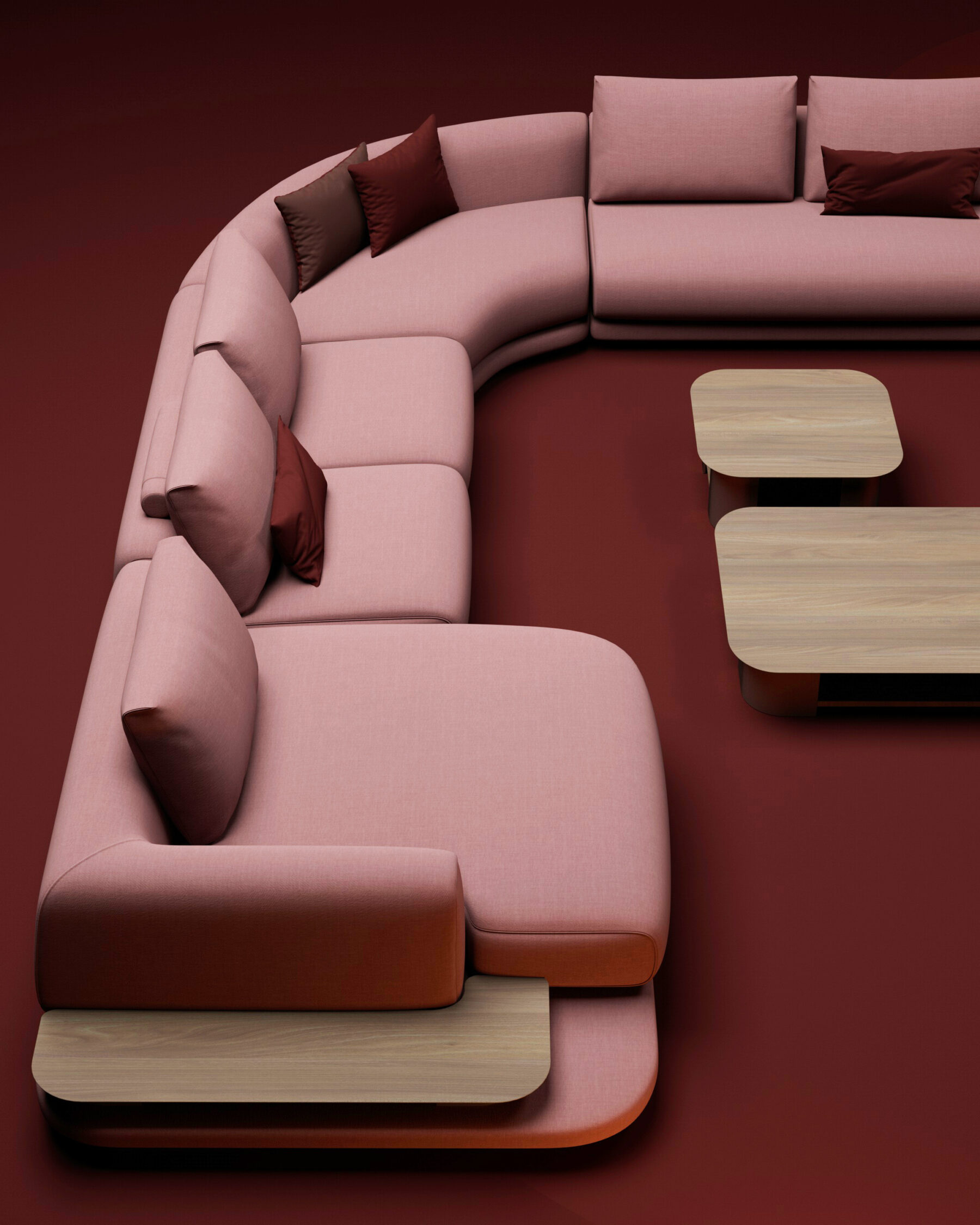 Canapé d’angle modulable rose et rouge avec tables intégrées en bois clair, présenté dans un espace minimaliste aux tons chauds.
