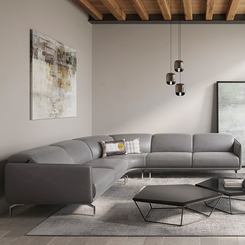 Canapé d’angle design en cuir gris avec piètement métallique fin, lignes épurées et assise spacieuse, dans un salon contemporain.