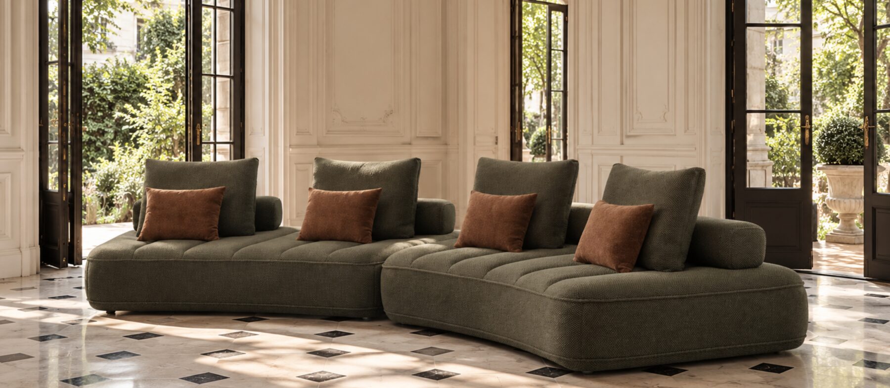 Canapé modulable aux lignes généreuses, habillé d’un tissu vert texturé et ponctué de coussins aux tons chauds, dans un intérieur parisien classique.