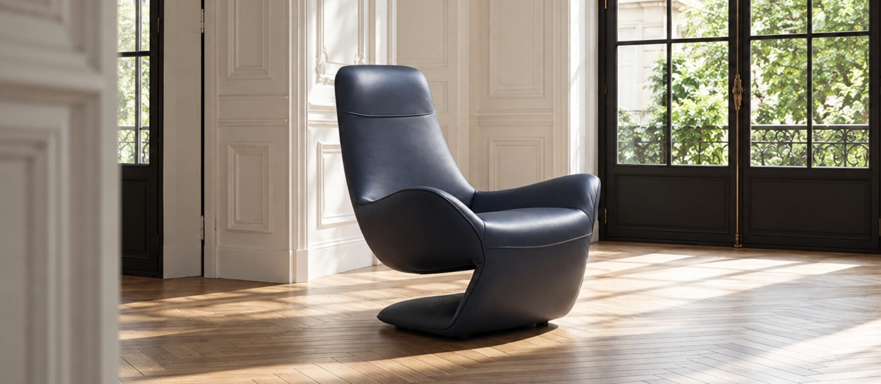 Sculptural armchair in deep blue leather, with a high back, fluid curves and enveloping armrests.