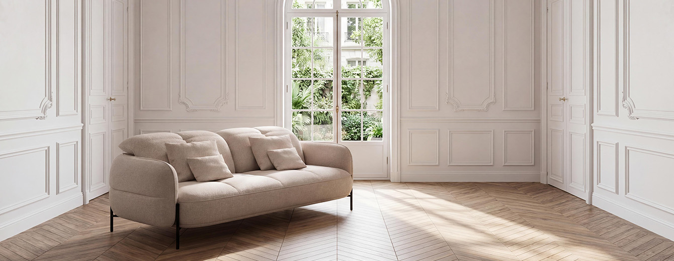 Canapé compact en tissu texturé beige, silhouette arrondie, têtières relevables et piètement métallique noir.
