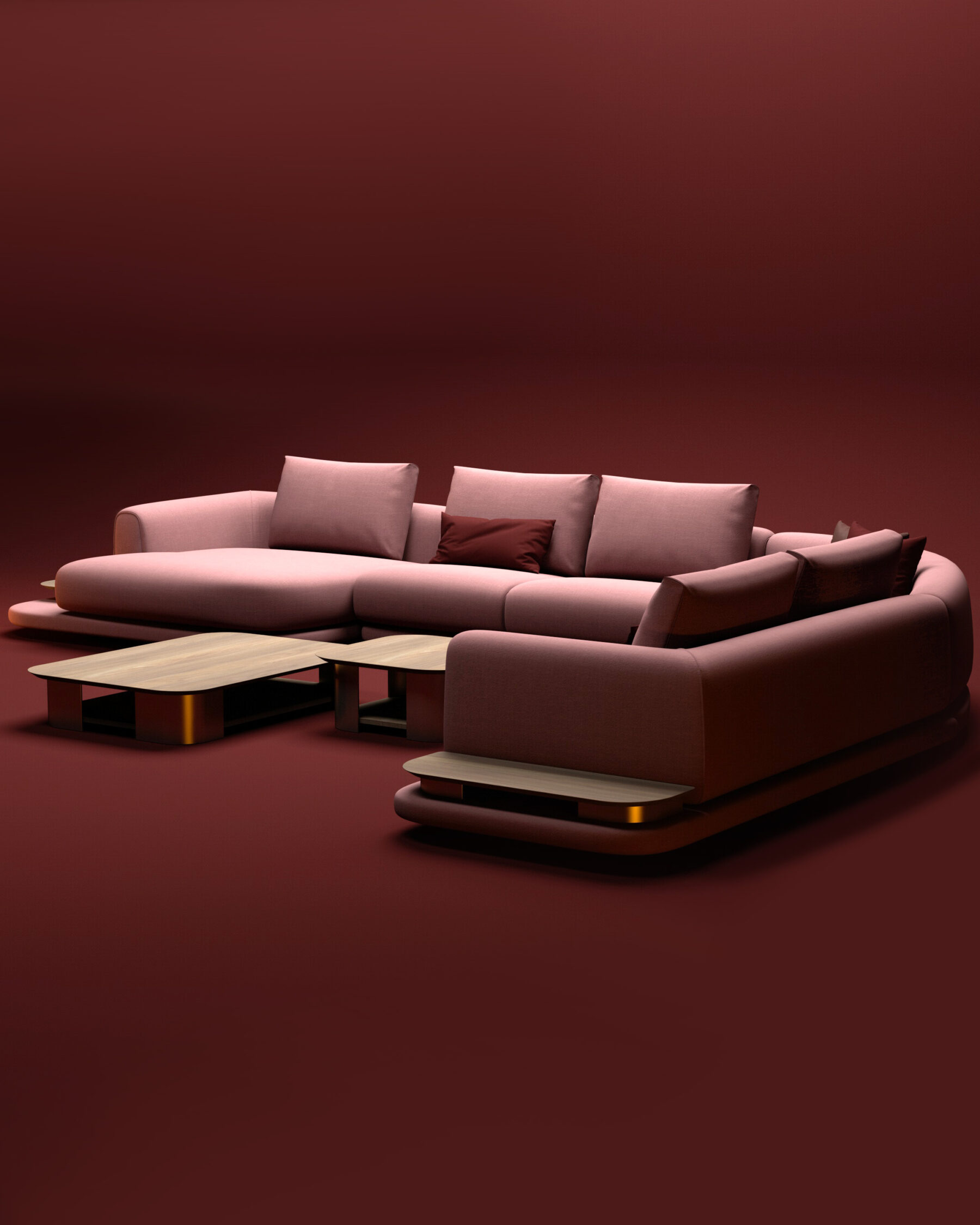 Modular blush pink sectional sofa with integrated light wood tables, set in a minimalist terracotta-toned space.